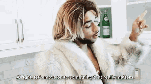a man in a fur coat is saying alright let 's move on to something that really matters