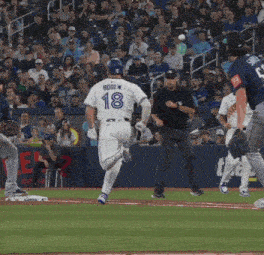 a baseball player with the number 18 on his back is running