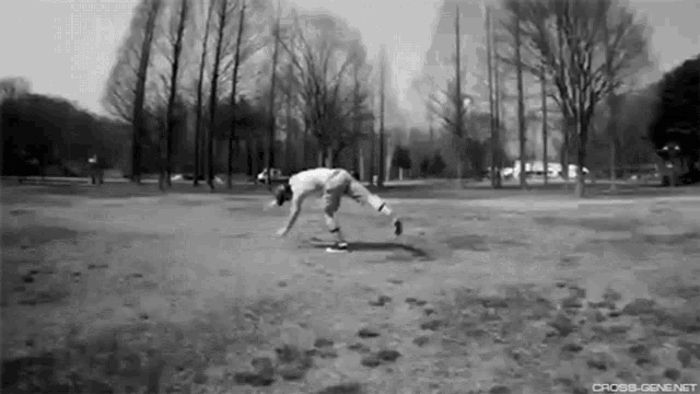 a black and white photo of a person doing a trick in a park .