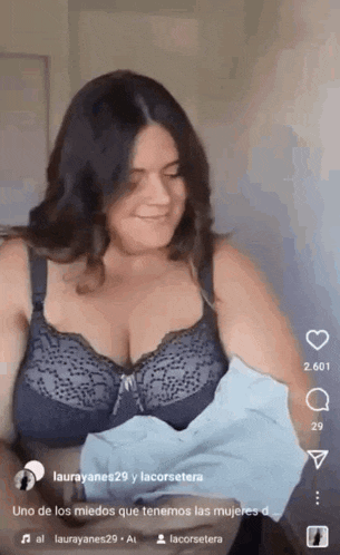 a woman in a bra is holding a baby and smiling .