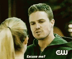 a man in a green jacket is talking to a woman in a ponytail .