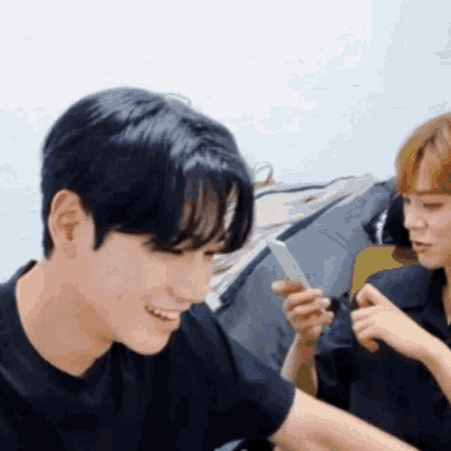 a man in a black shirt is smiling while holding a knife in his hand