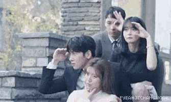 a group of people are posing for a picture while standing next to each other .