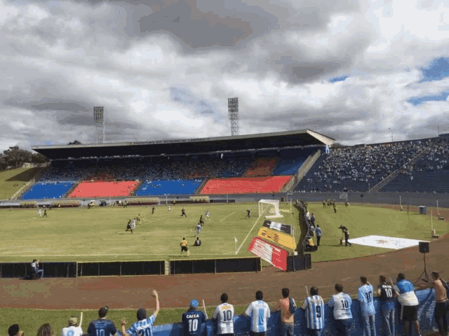 a group of people watching a soccer game in a stadium with one wearing the number 10