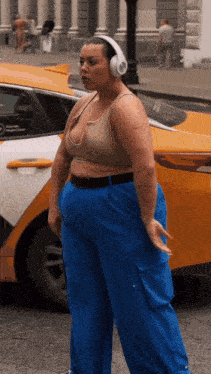 a woman wearing headphones is standing in front of a car