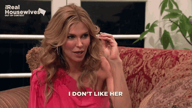 a woman sitting on a couch with the words i don 't like her on the bottom