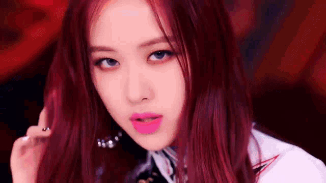 a close up of a woman with red hair and pink lipstick looking at the camera .