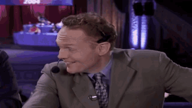 a man in a suit and tie with a microphone on his head