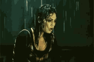 a woman in a black shirt is standing in the rain