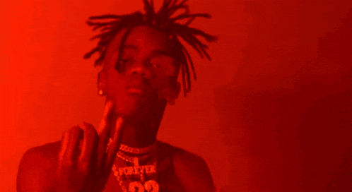 a man with dreadlocks is wearing a necklace with the number 99