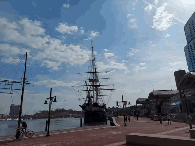 a man riding a bike next to a large ship