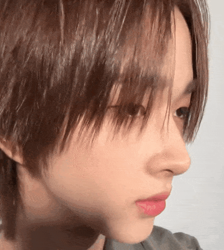 a close up of a person 's face with a very short haircut .