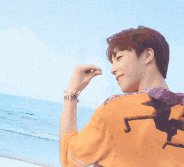 a man in an orange shirt with a witch on the back