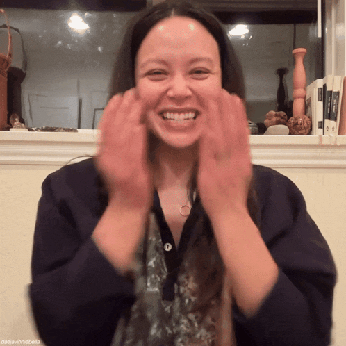 a woman is smiling with her hands in front of her face and the name danavinniebella is on the bottom of the photo