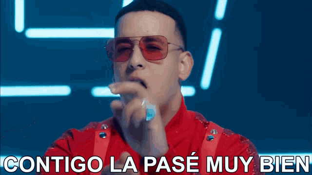 a man wearing sunglasses and a red jacket says contigo la pase muy bien