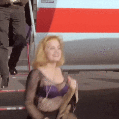 a woman in a purple bra stands in front of a red and white van that says emergency evacuation