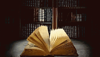 an open book is sitting in front of a bookshelf in a library