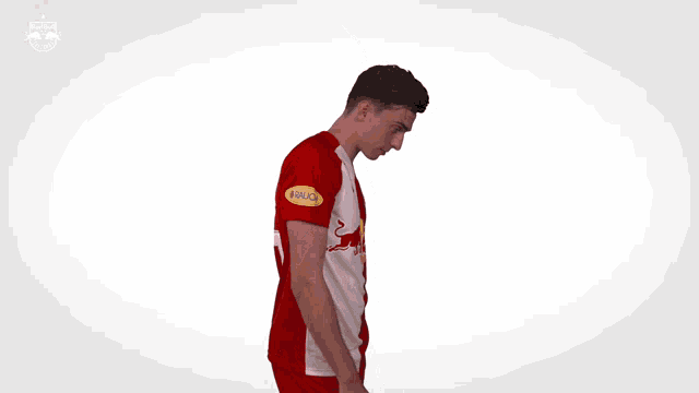 a man wearing a red and white jersey with a red bull on the front