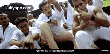 a group of men in white shirts are sitting next to each other and making funny faces .