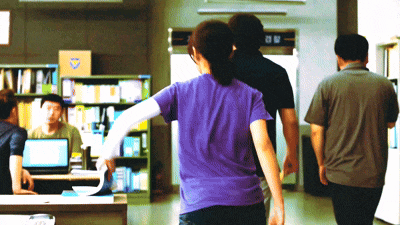 a woman in a purple shirt is walking with a man in a grey shirt
