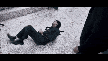 a man in a suit and tie is laying on a tiled floor