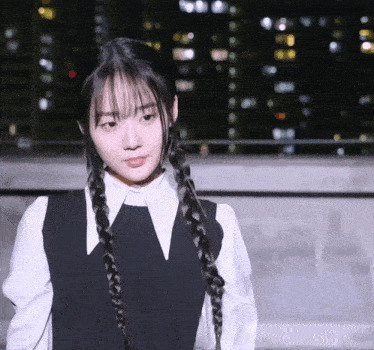 a girl with braids and a white shirt has a v on her collar