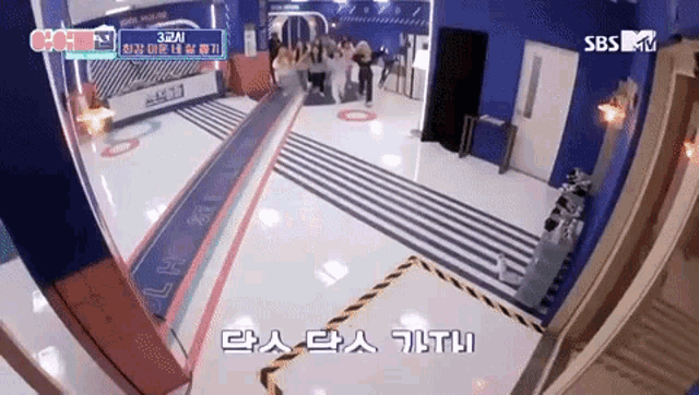 a group of people are standing in a room with sbs tv written on the bottom