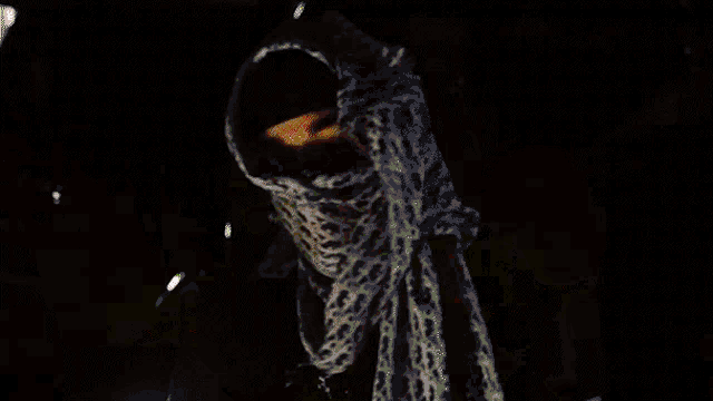 a blurred image of a person with a green scarf around their neck