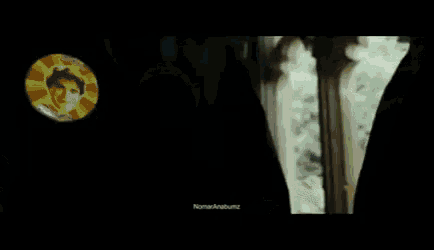 harry potter is standing in a hallway with a group of people walking behind him .