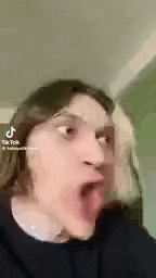 a man is making a funny face with his tongue sticking out .