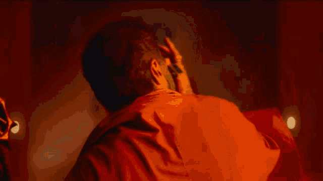 a man in a red robe is holding a large sword in his hand .