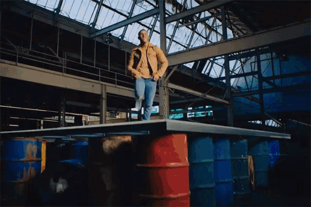 a man standing on top of a barrel in a large building