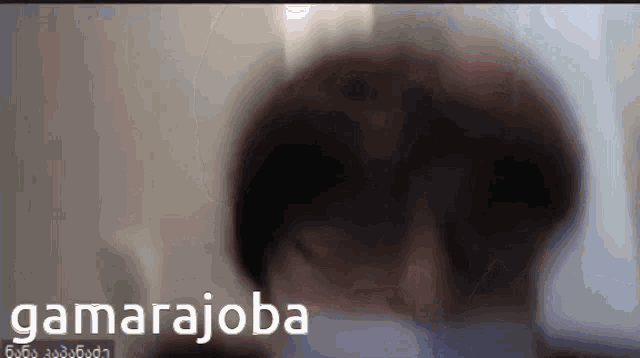 a blurry picture of a person with the word gamarajoba in the upper right corner