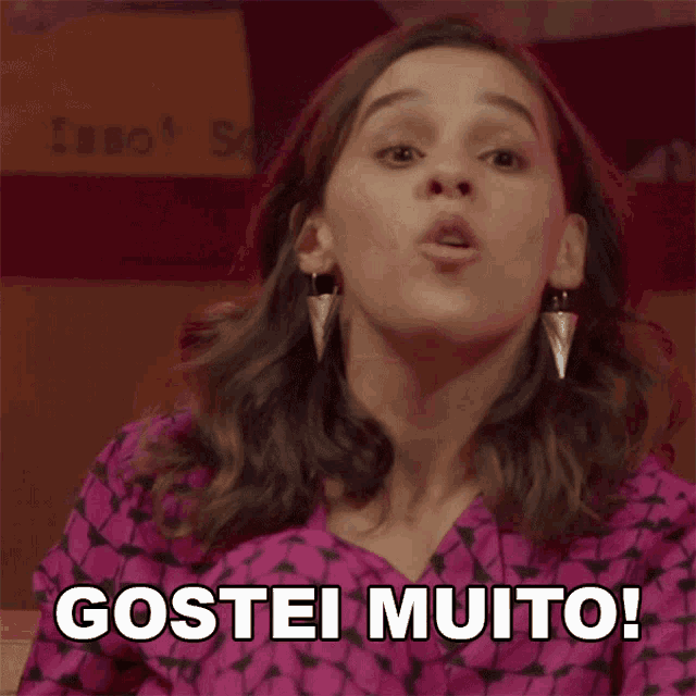 a woman in a pink shirt says " gostei muito " in a foreign language