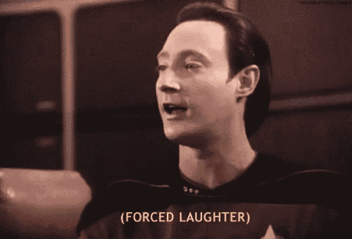 a man in a star trek uniform is sitting in a chair and looking at something .