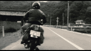 a person riding a motorcycle with a license plate that has 215 on it