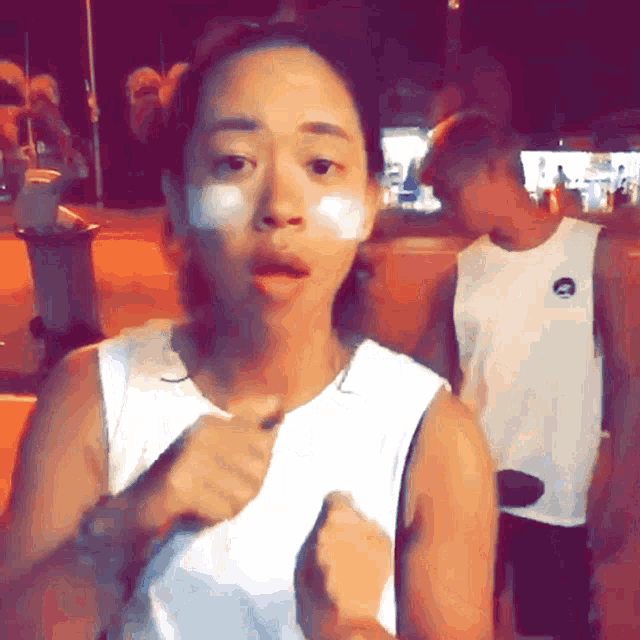 a woman wearing a white nike tank top stands in front of a man wearing a white nike tank top