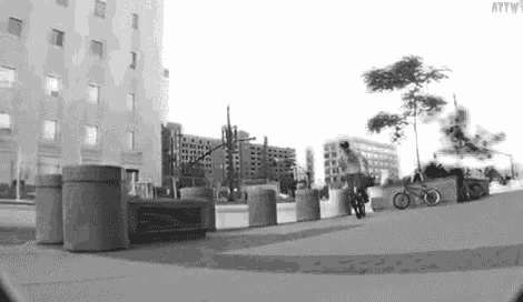a man is riding a bike down a sidewalk in a city .
