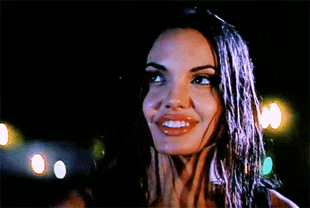 a close up of a woman 's face with lights behind her