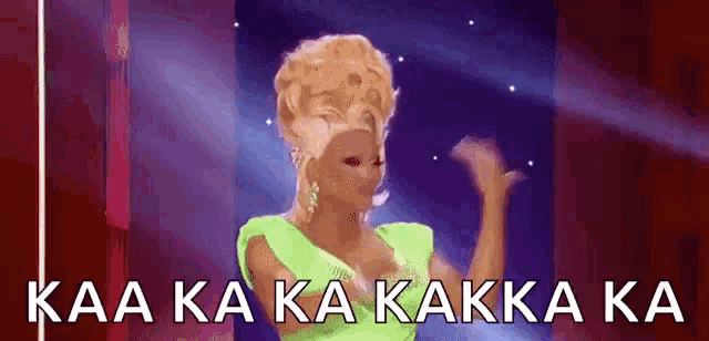 a woman in a green dress is dancing on a stage with the words kaa ka ka kakka ka written on the bottom .