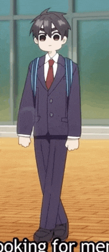 a boy in a suit and tie is standing in front of a window .