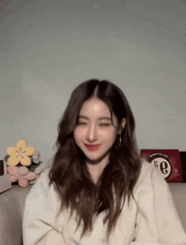 a woman in a white sweater with the letter e on her chest