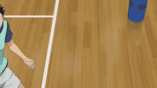 a man in a blue shirt is playing volleyball with a ball on his head