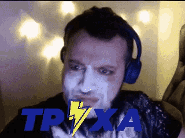 a man with white paint on his face is wearing headphones and the word trxa is on the screen