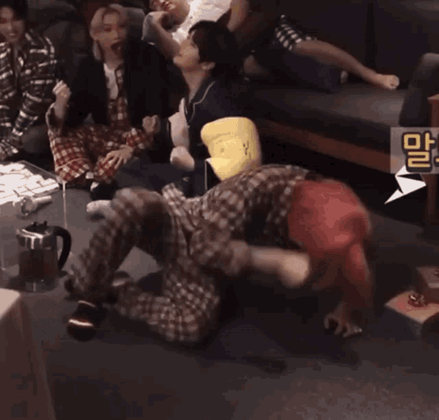 a group of people are sitting on a couch and one of them has a yellow pillow that says ' a ' on it
