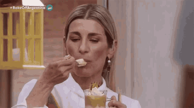 a woman is eating something with a spoon and the words bake off argentina are visible