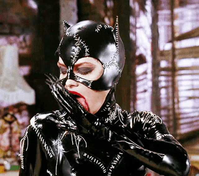 a woman in a catwoman costume is covering her mouth