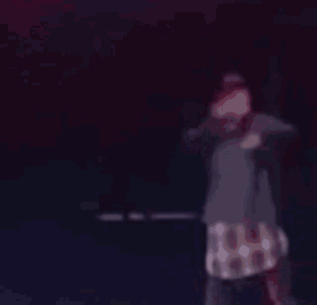 a blurry picture of a man singing into a microphone on a stage