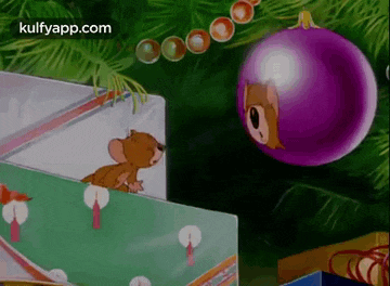a cartoon of a mouse looking out of a box next to a purple christmas ball .