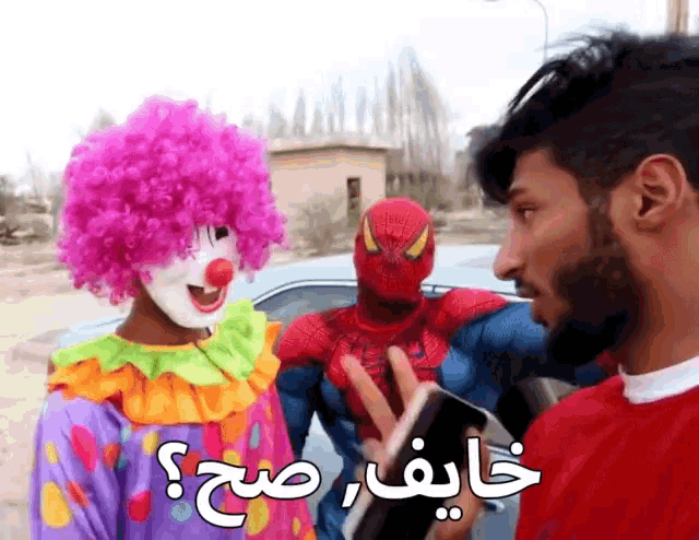 a man in a spiderman costume is talking to a clown